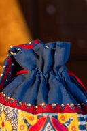 Handmade blue appliqué potli featuring traditional Indian embroidery and beadwork.