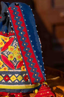 Artisan handcrafted blue potli with patchwork and intricate handwork.