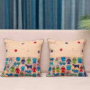 Cream cushion cover with folk-inspired figures and houses
