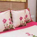 Cream bedsheet with pink lotus motifs and green leaves
