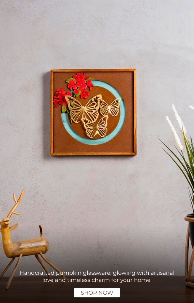Decorative wall art with butterfly and floral design on a gray wall, accompanied by a deer statue and plant.